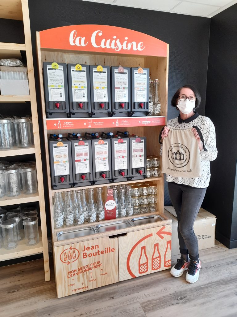 Sophie, manager of Mademoiselle Vrac Bruz, stands in front of her Jean Bouteille bulk liquid department