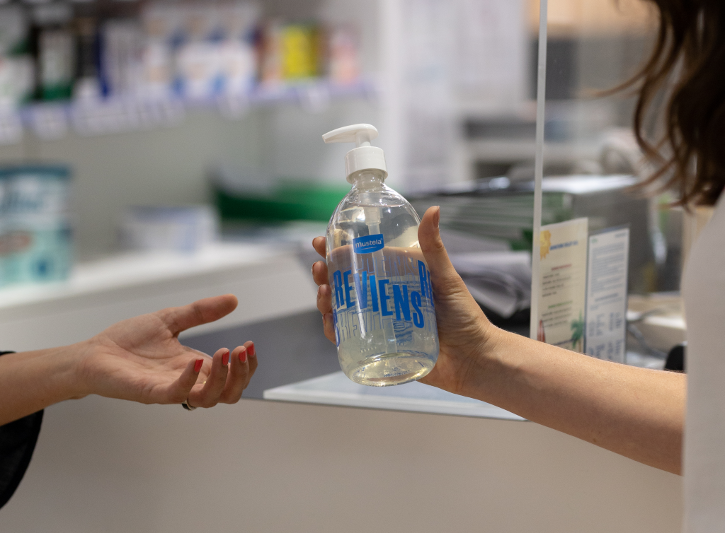 Une pharmacienne vend un flacon de gel lavant mustela réutilisable à l'infini